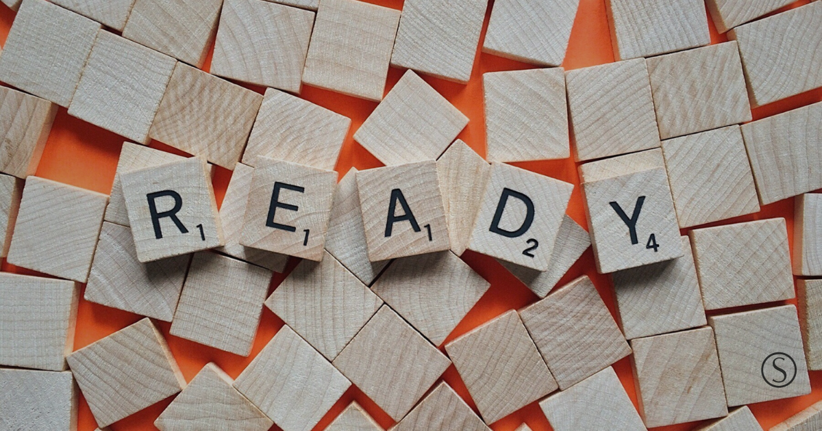 Wooden letter tiles spelling “READY,” representing financial emergency preparedness.