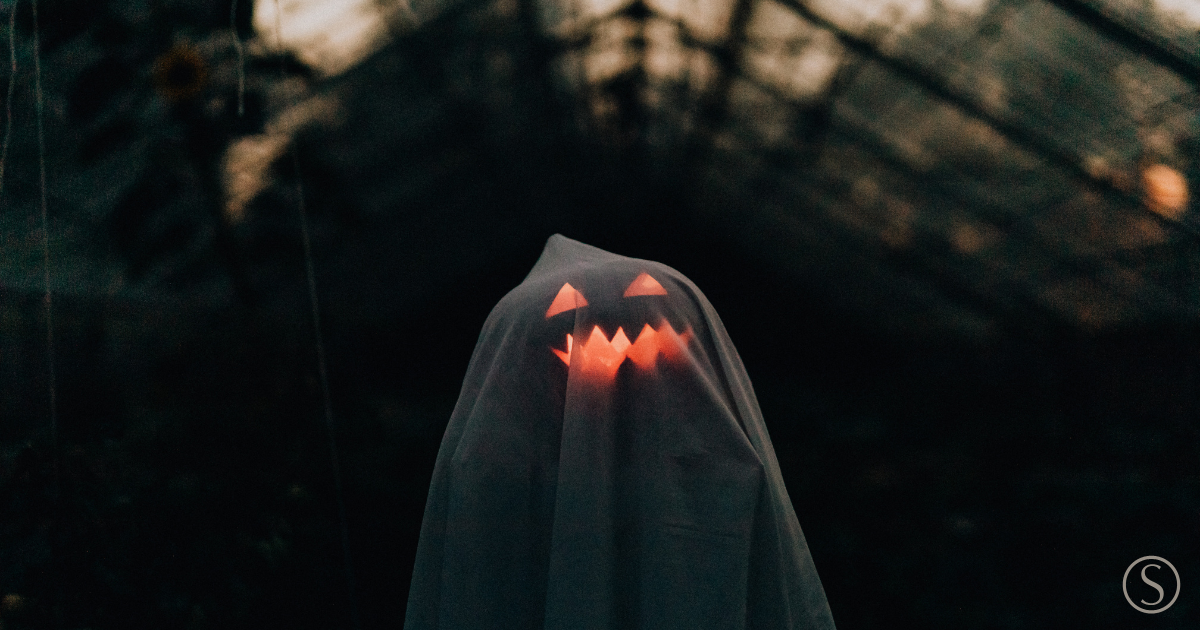 Ghost with a glowing jack-o'-lantern representing the ghosts of financial accounts past